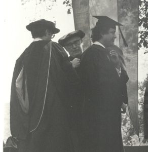 black and white photo of Gordon Davis being hooded at a commencement ceremony